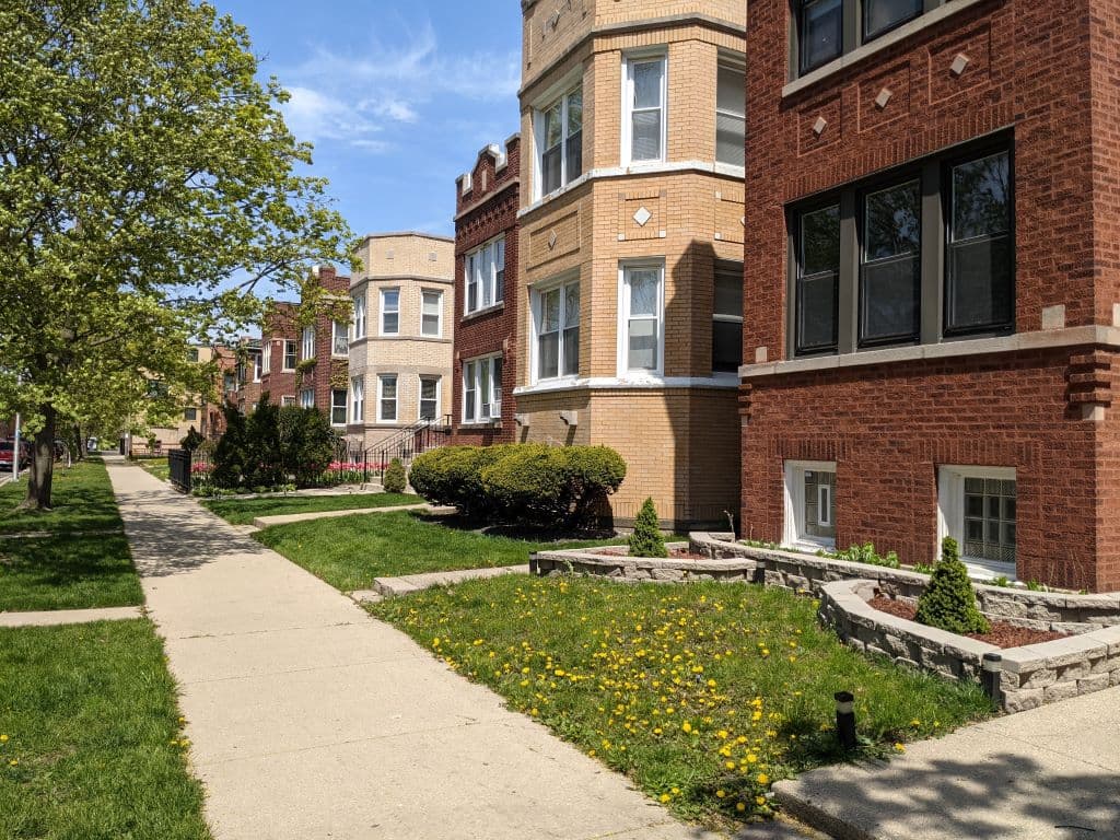 Tree-lined street with classic brick multifamily buildings